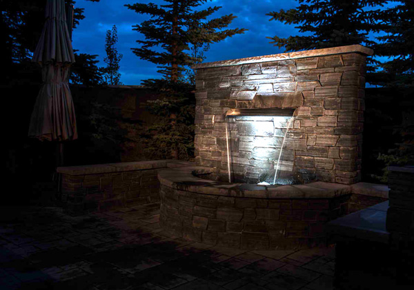 Stunning outdoor water feature in the back yard landscape design.